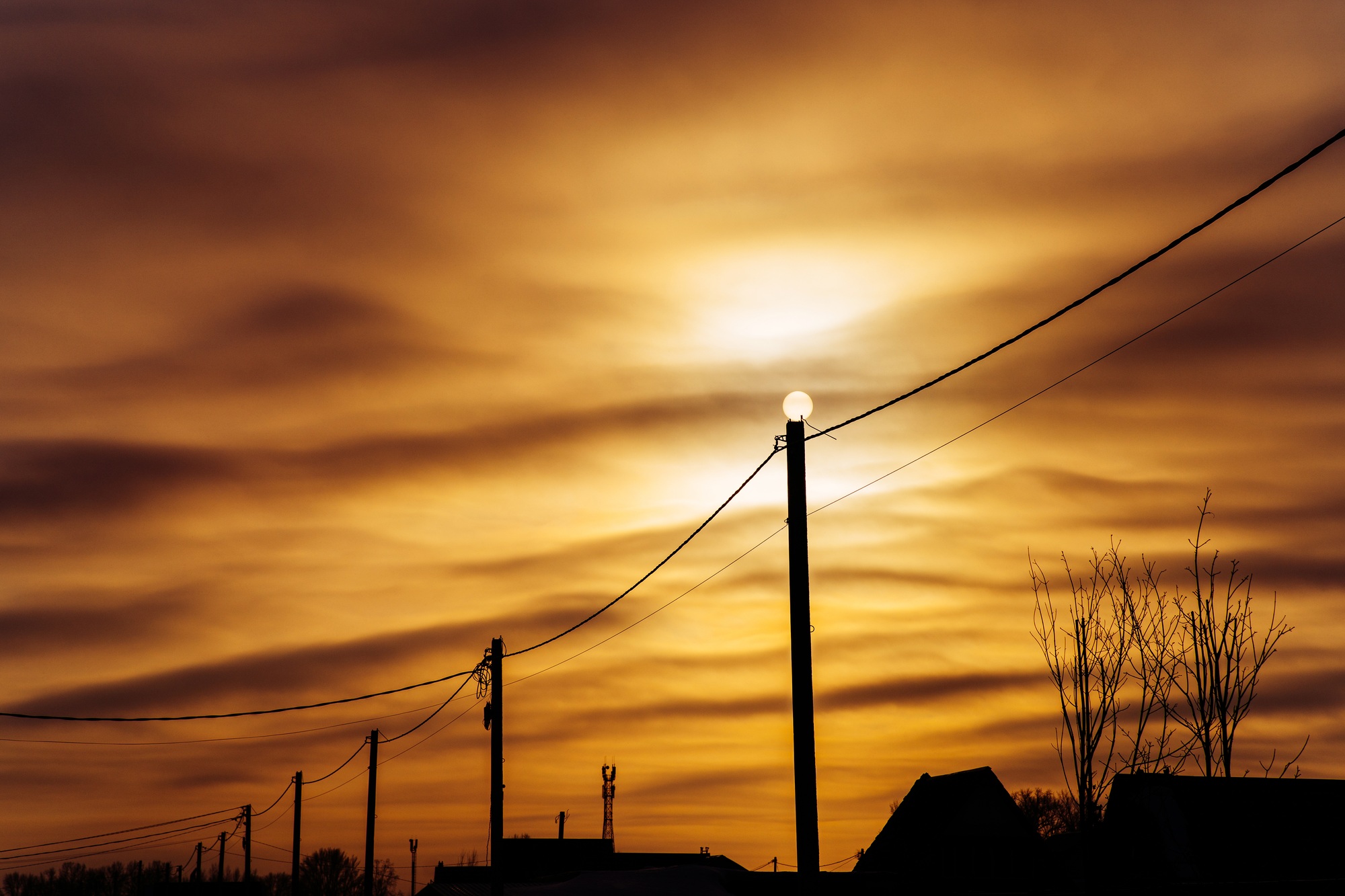 Sun on an electric pole before sunset. Concept of lack of electricity, energy crisis